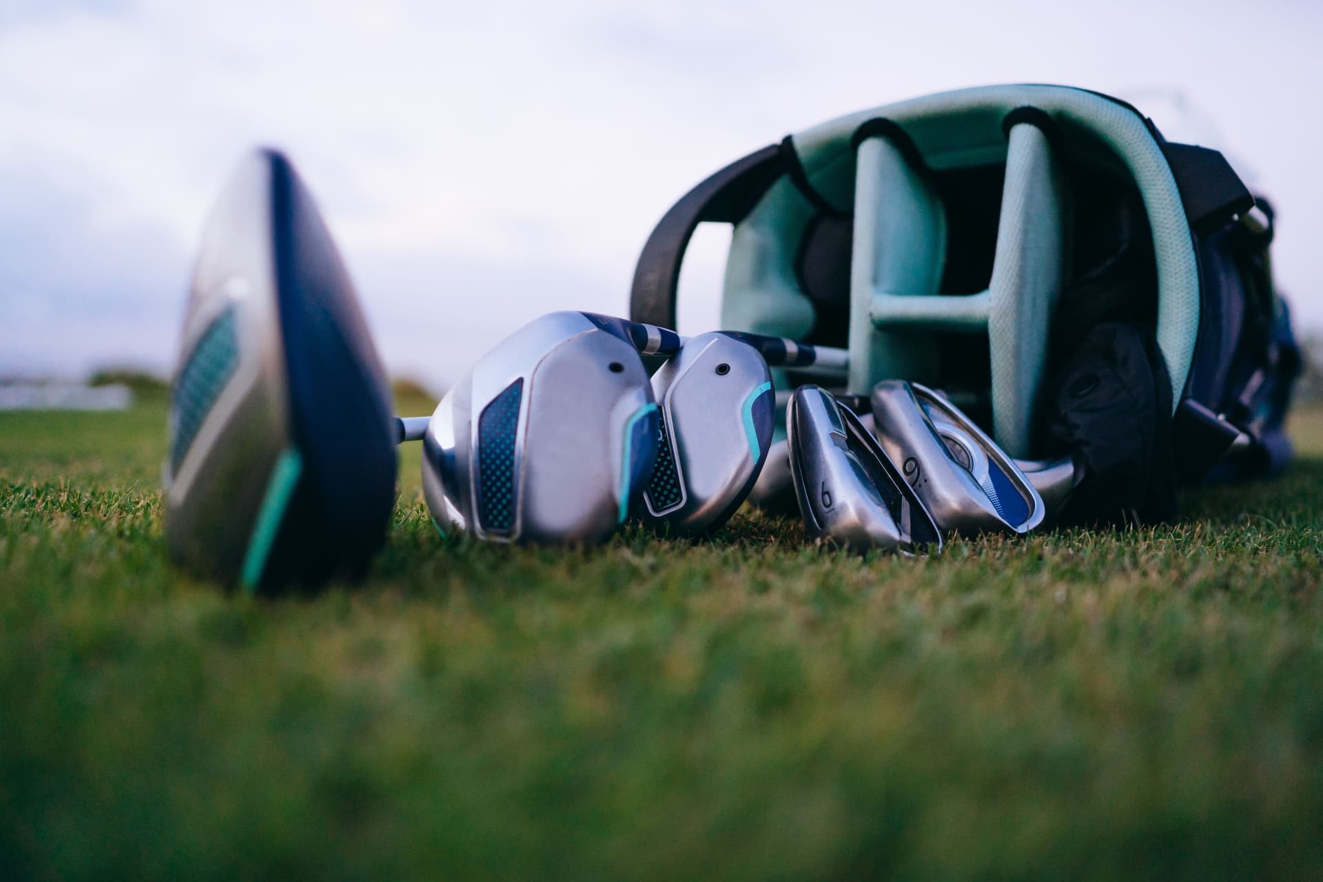A golf bag and clubs standing on a fairway in hard afternoon light